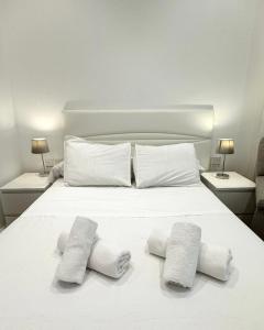 1 dormitorio con 1 cama blanca y 2 toallas en Delightful City Centre Studio Clarendon Apartment - Grand Central House en Gibraltar