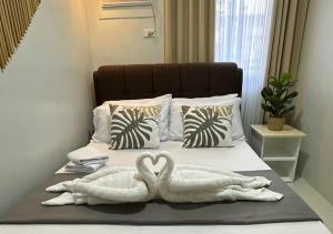 two swans towels sitting on top of a bed at Affordable Summer Homes with FREE Pool, Gym and Parking near Puerto Princesa Palawan Airport -T21Kunzite in Puerto Princesa City
