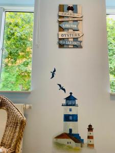 ein Leuchtturmzeichen und Vögel an der Wand in der Unterkunft Casa Cinzia Sara in Eckernförde