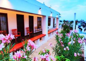 a house with red chairs and flowers on a balcony at The French Villa Elite in Puducherry +13 photos