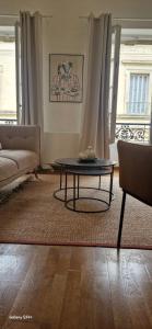 a living room with a table and a couch at Escale citadine au centre d'Avignon, climatisation, appartement de charme, spacieux et lumineux in Avignon