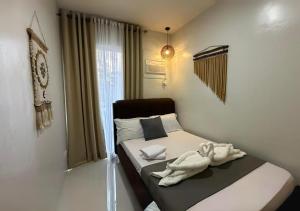 1 dormitorio con 1 cama con toallas en Affordable Summer Homes with FREE Pool, Gym and Parking near Puerto Princesa Palawan Airport -T21Kunzite en Puerto Princesa