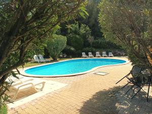 una piscina con tumbonas y un complejo en Cit'Hotel Hotel Prime - A709, en Saint-Jean-de-Védas