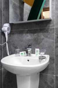 y baño con lavabo blanco y espejo. en Green Center Gili, en Gostivar