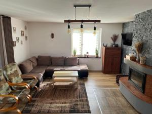 - un salon avec un canapé et une cheminée dans l'établissement Dom pod Skrzycznem, à Lipowa