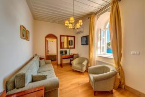 ein Wohnzimmer mit einem Sofa und 2 Stühlen in der Unterkunft Apollonion Palace in Ermoupoli