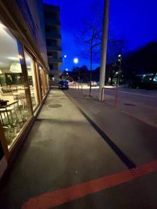 ein leerer Gehweg vor einem Gebäude nachts in der Unterkunft *Veranda's rooms* - Free parking in central Lugano in Lugano