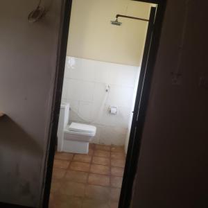 a bathroom with a white toilet in a room at Safari Junction Backpackers hostel in Iringa