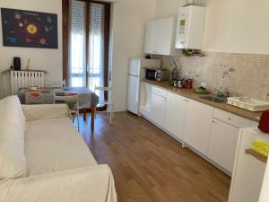 a kitchen with a couch and a table in a room at Room Saronno + B&B in Saronno
