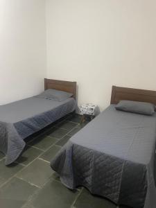 two beds sitting next to each other in a room at Casa com 3 quartos in Itu