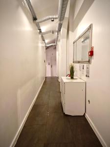 a hallway of an office with a small white cabinet at Apartamenty Hoża Attic Studio in Warsaw
