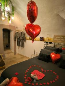 a room with a bed with two red heart balloons at Les Bains d'Aphrodite in Auriol