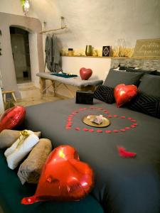 a living room with a couch with red heart shaped pillows at Les Bains d'Aphrodite in Auriol