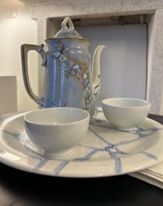 a blue and white pitcher and two bowls on a plate at Le Lampade di Brienno Apartment in Brienno