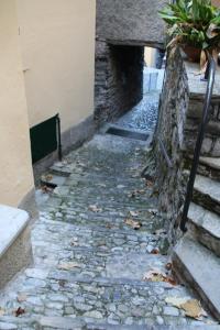 a stone alley with a stone wall and a staircase at Le Lampade di Brienno Apartment in Brienno