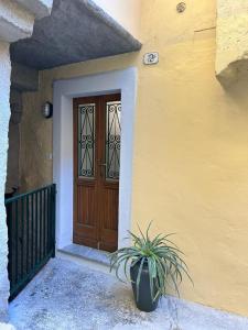 a door of a house with a potted plant in front of it at Le Lampade di Brienno Apartment in Brienno