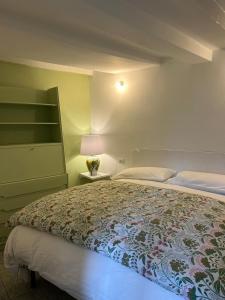 a bedroom with a large bed and a lamp at Le Lampade di Brienno Apartment in Brienno