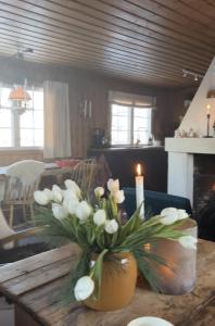 a vase filled with white flowers on a table at Cozy family friendly cabin at beautiful location! in Geilo