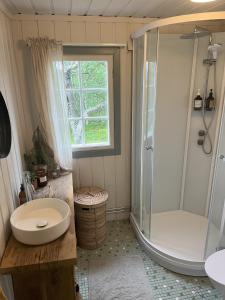 y baño con ducha, aseo y lavamanos. en Cozy family friendly cabin at beautiful location!, en Geilo