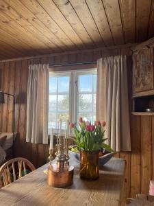 a dining room table with flowers and candles on it at Cozy family friendly cabin at beautiful location! in Geilo