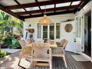 a patio with a wooden table and chairs at Bamboo Beach House & Studio in Byron Bay