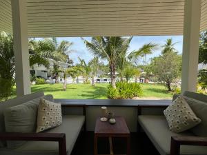 - une terrasse couverte avec deux canapés et une vue sur la cour dans l'établissement Moorea Boutique Resort Samui, à Koh Samui 