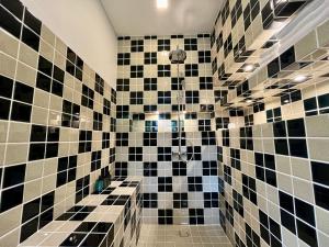 uma casa de banho com paredes em azulejo preto e branco em Moorea Boutique Resort Samui em Koh Samui 