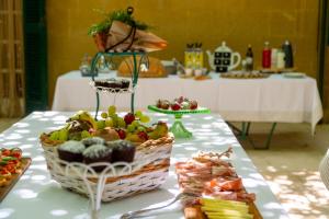 a table topped with a basket of fruit and pastries at Villa Pesce in Selva di Fasano