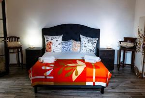 - une chambre avec un lit doté d'une couverture et d'oreillers colorés dans l'établissement Les Canoubiers Luxe et sérénité au cœur de Saint-Tropez Suites spacieuses avec jardin enchanteur, à Saint-Tropez