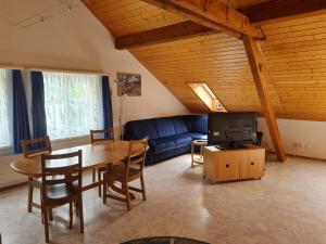 uma sala de estar com um sofá azul e uma mesa em Dachwohnung in Welschenrohr em Welschenrohr