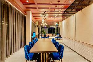a conference room with a long table and blue chairs at Scarletz suites klcc Bukit Bintang by lulu in Kuala Lumpur +73 photos