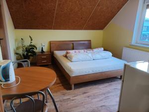 a bedroom with a bed and a table and a desk at Zefirek in Stegna