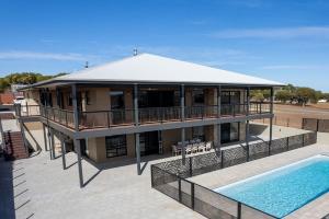 a house with a swimming pool in front of it at The Lux Country Retreat - heated swimming pool - immaculate views and stylish comfort! in Port Lincoln