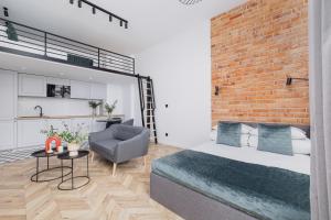 a bedroom with a bed and a brick wall at Apartment with Balcony - Starowiślna 41 in Kraków