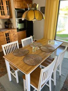 una mesa de comedor de madera con sillas y una lámpara de araña en Kaffestugan, en Hällefors