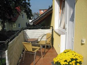 a patio with a table and chairs on a balcony at Ferienwohnungen Familie Dinda in Baabe