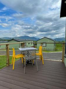 a table and two chairs on a deck at Serena Holiday Caravan in Bassenthwaite