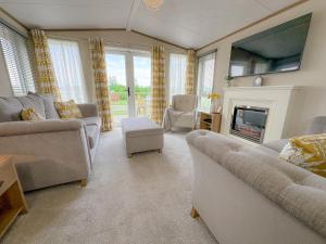a living room with two couches and a fireplace at Serena Holiday Caravan in Bassenthwaite