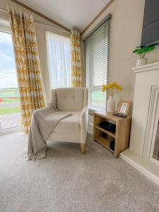 a living room with a chair and a fireplace at Serena Holiday Caravan in Bassenthwaite