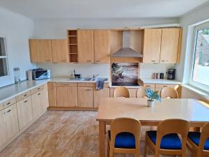 a kitchen with wooden cabinets and a table with chairs at Apartment 1 in Diepholz