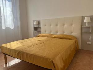 a bedroom with a large bed with a yellow bedspread at Campitur in Campomarino