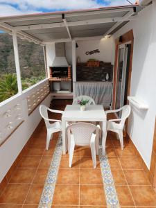 einen Balkon mit einem weißen Tisch und Stühlen in der Unterkunft MIRADOR SAN ROQUE in Las Palmas de Gran Canaria