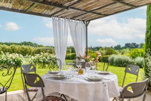 a table with a white tablecloth and chairs under a pergola at Cantagrillo Boutique Resort in Vinci