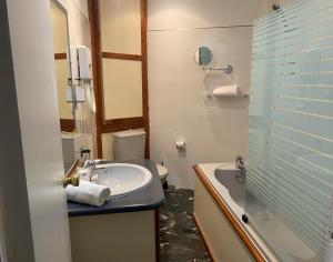 a bathroom with a sink and a shower and a toilet at Grand Hôtel De Calvi in Calvi