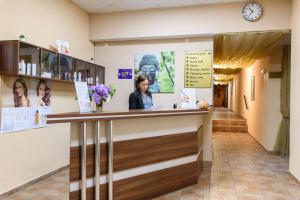 a woman standing at a counter in a hospital lobby at Grand Royale Apartment Complex & Spa in Bansko
