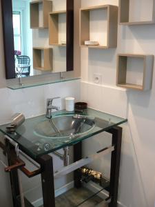 um lavatório de casa de banho com uma bancada de vidro em VANNES STUDIO RECENT AU CALME em Vannes