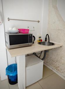 a microwave sitting on a table next to a sink at Apartamenty Wilcza - City Center in Warsaw
