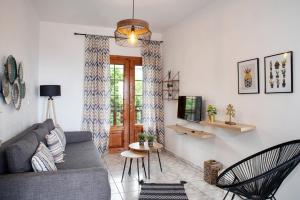a living room with a couch and a tv at Ostria Hotel in Skala Potamias