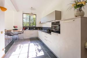 a kitchen with white cabinets and a table in it at Lesa villa near the lakeside in Lesa
