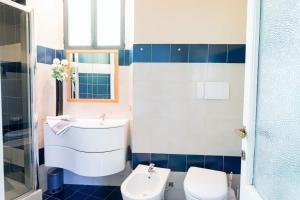 Un baño azul y blanco con lavabo e inodoro. en Lesa villa near the lakeside, en Lesa